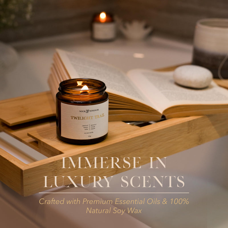 Lit Cosy candle beside an open book on a wooden bath tray